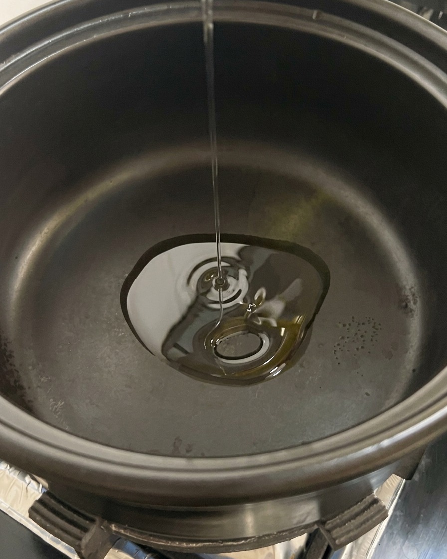 熱した油を入れた鍋に、スライスしたマッシュルームを入れている様子。