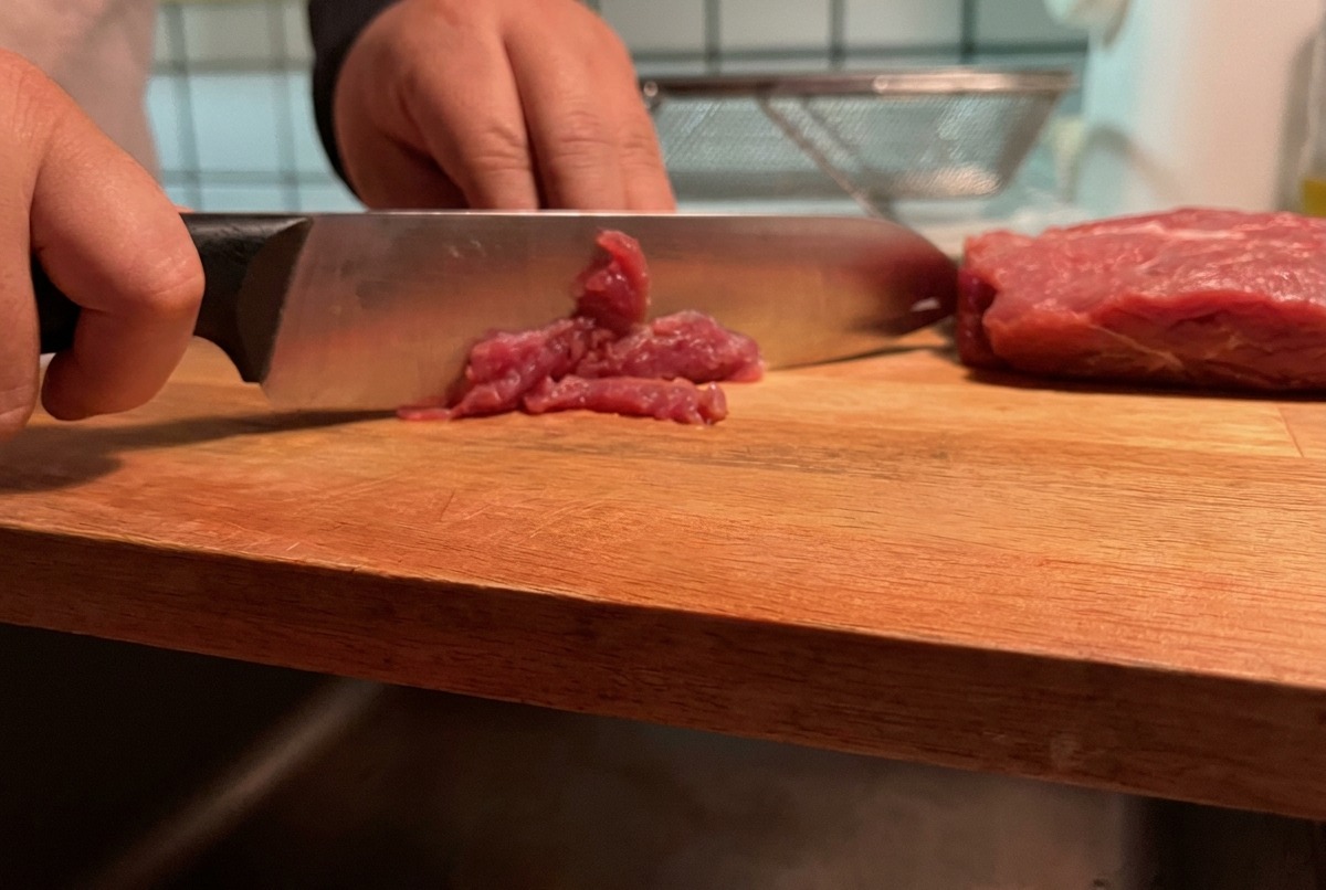 まな板の上で豚赤身肉を薄切りにしている様子。