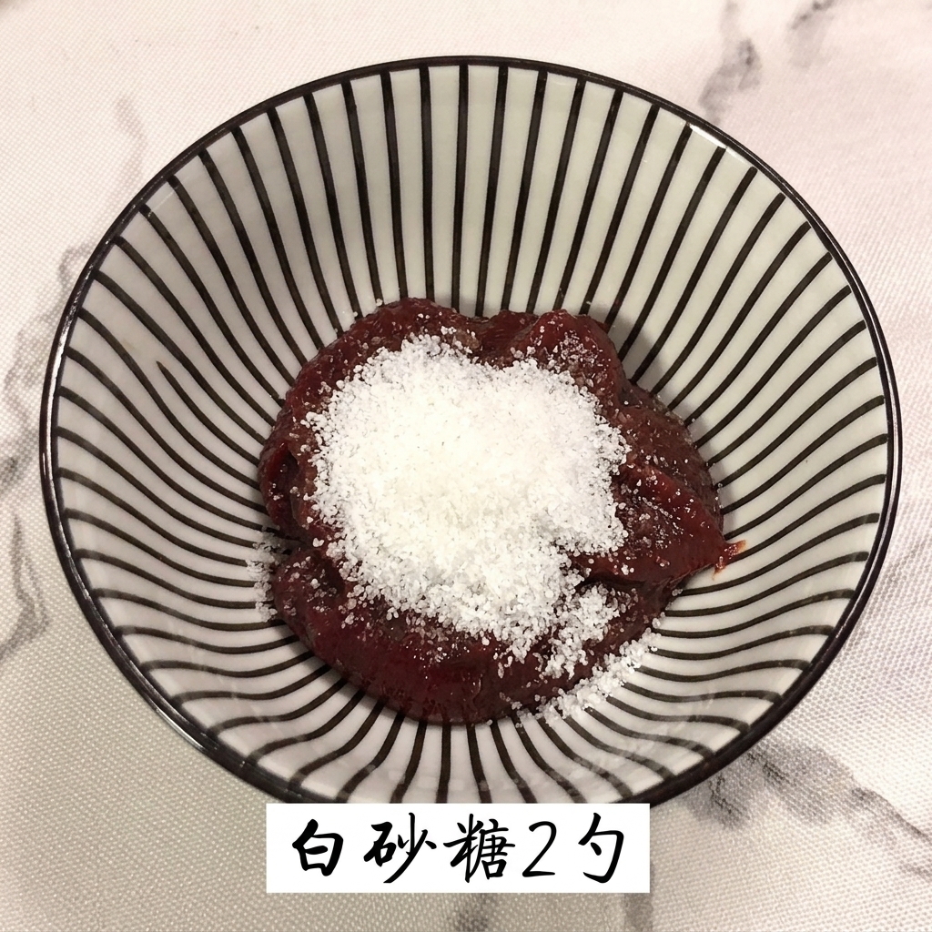 赤いコチュジャンが入ったボウルにグラニュー糖を加えている様子