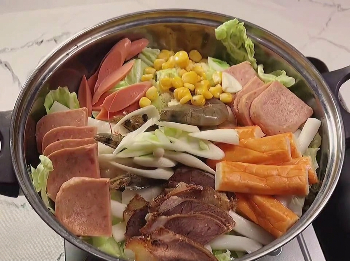 具材の上に赤い辛味ペーストをかけている様子
