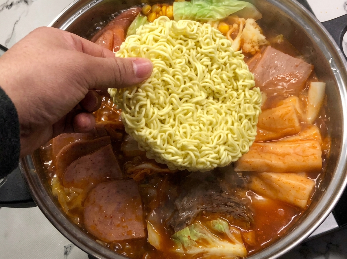 沸騰して赤いスープの中でインスタント麺を煮込んでいる様子