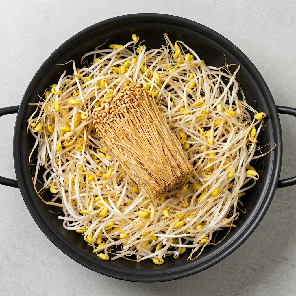 鍋にきれいに並べられたもやし、豆腐、えのき、スパム、ソーセージ