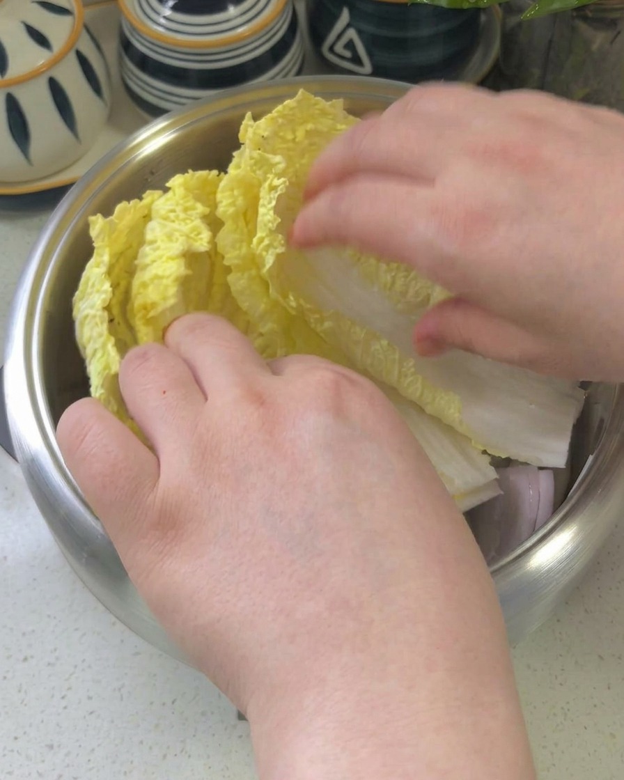 鍋の中にキャベツ、ズッキーニ、えのき、牛肉、トッポギ、スパム、豆腐が綺麗に配置されている様子。