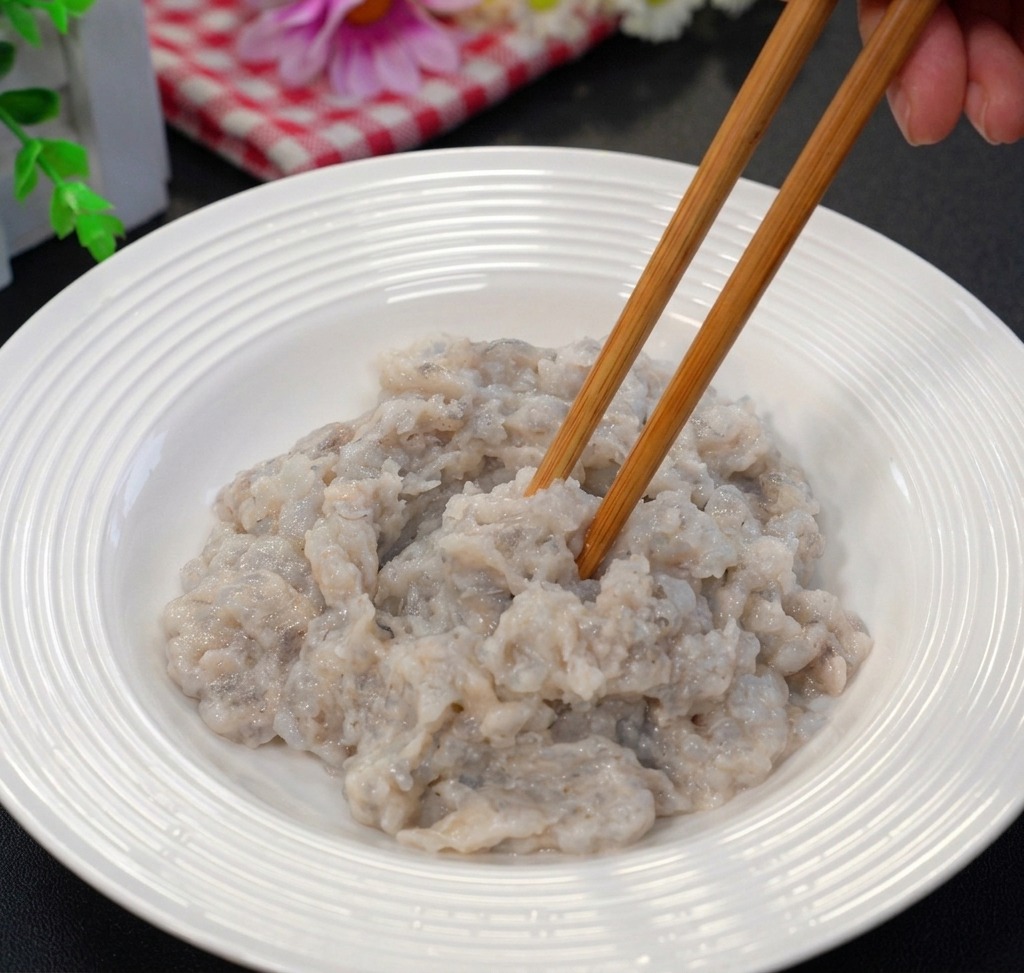 白いボウルの中で、海老のすり身と調味料を菜箸で混ぜ合わせている様子。