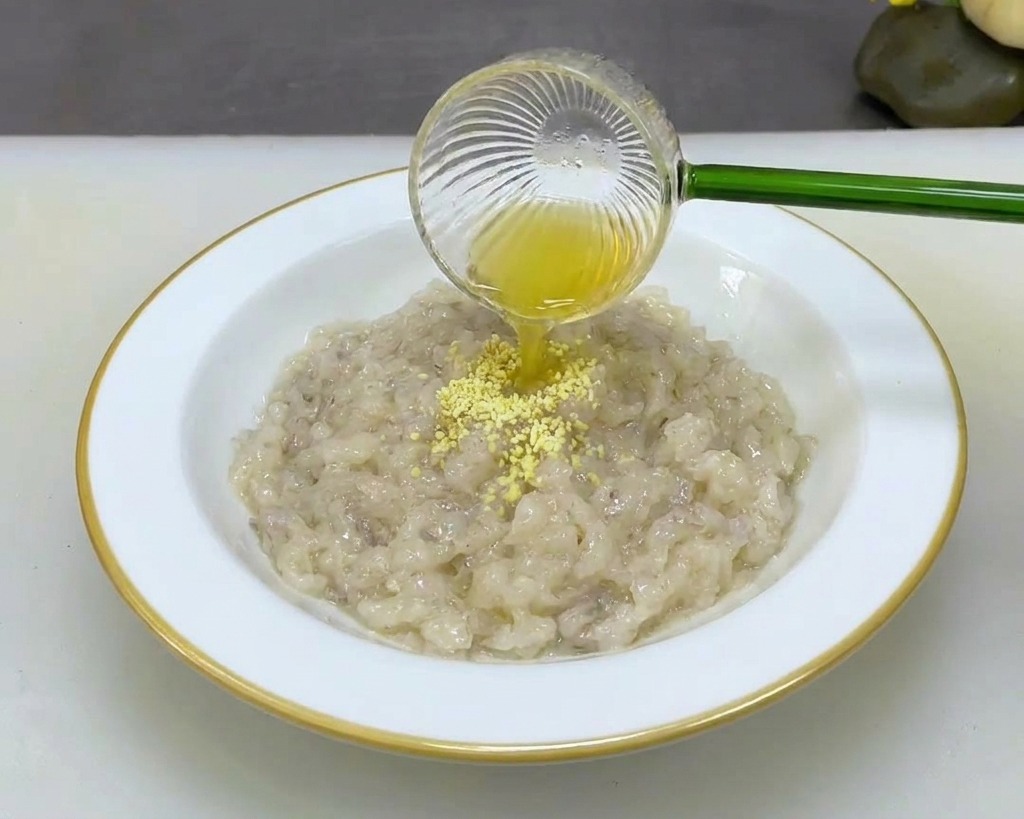 白いボウルに入った海老のすり身に、調味料を振りかけている様子。