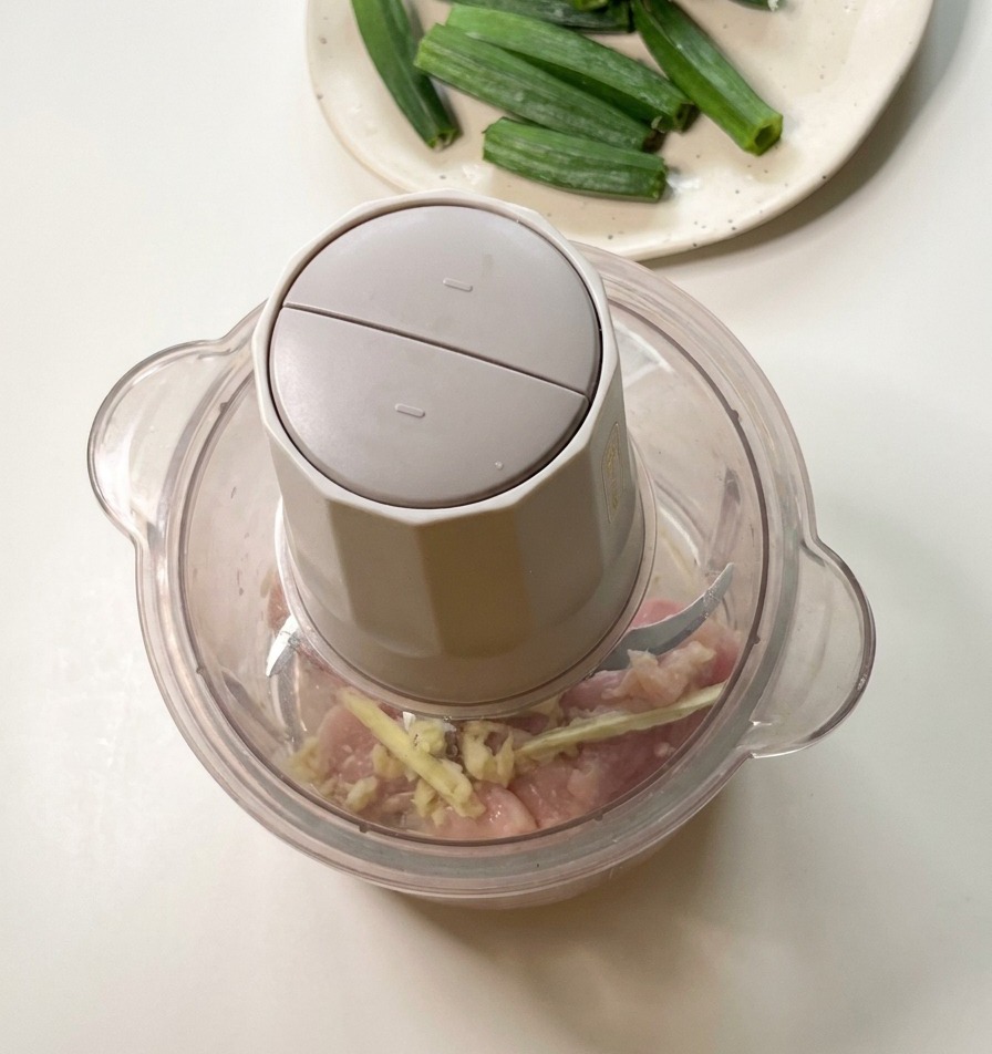 フードプロセッサーの中に、カットした鶏肉とオクラの種が入っている準備完了の状態。