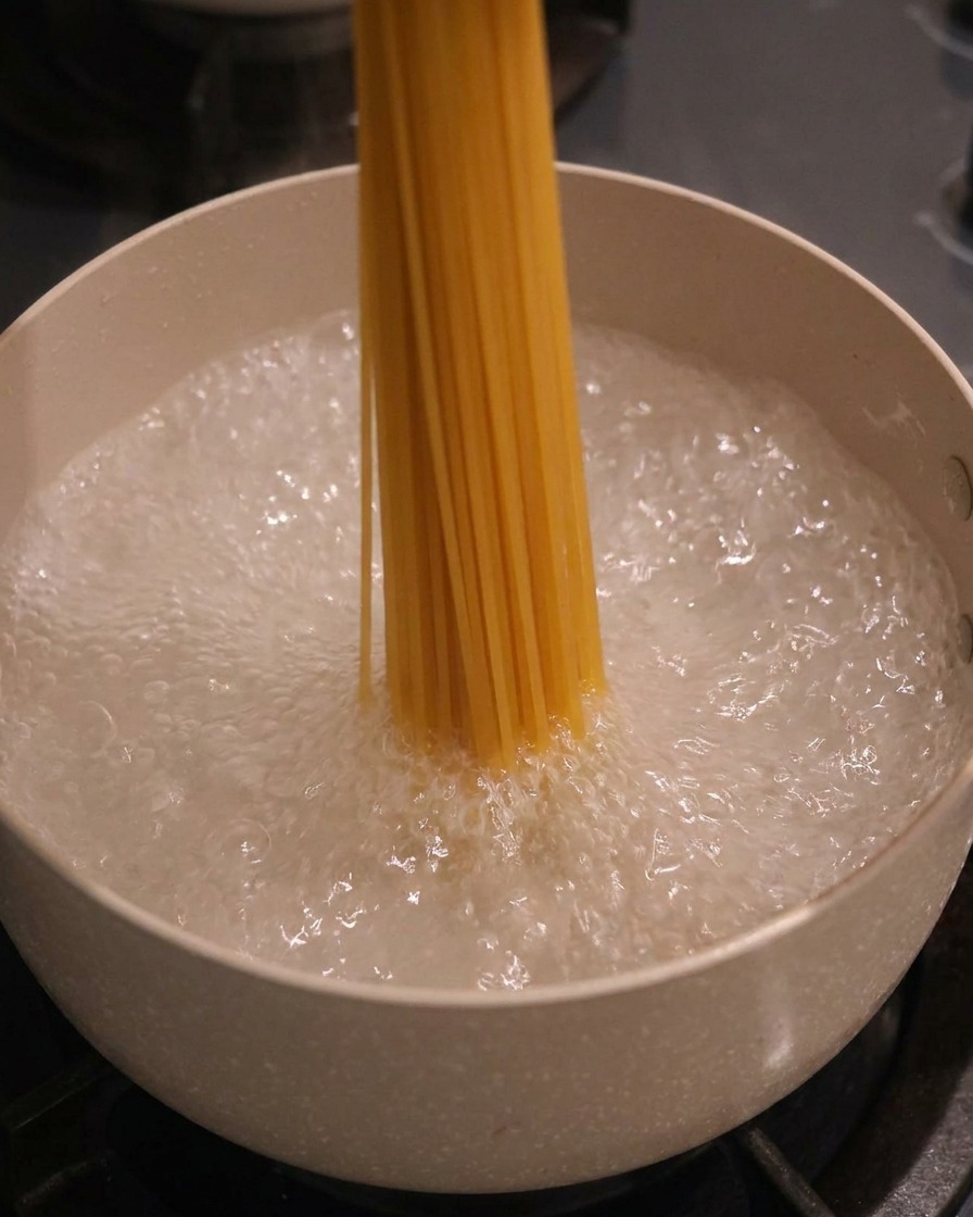沸騰したお湯にスパゲッティを入れる様子