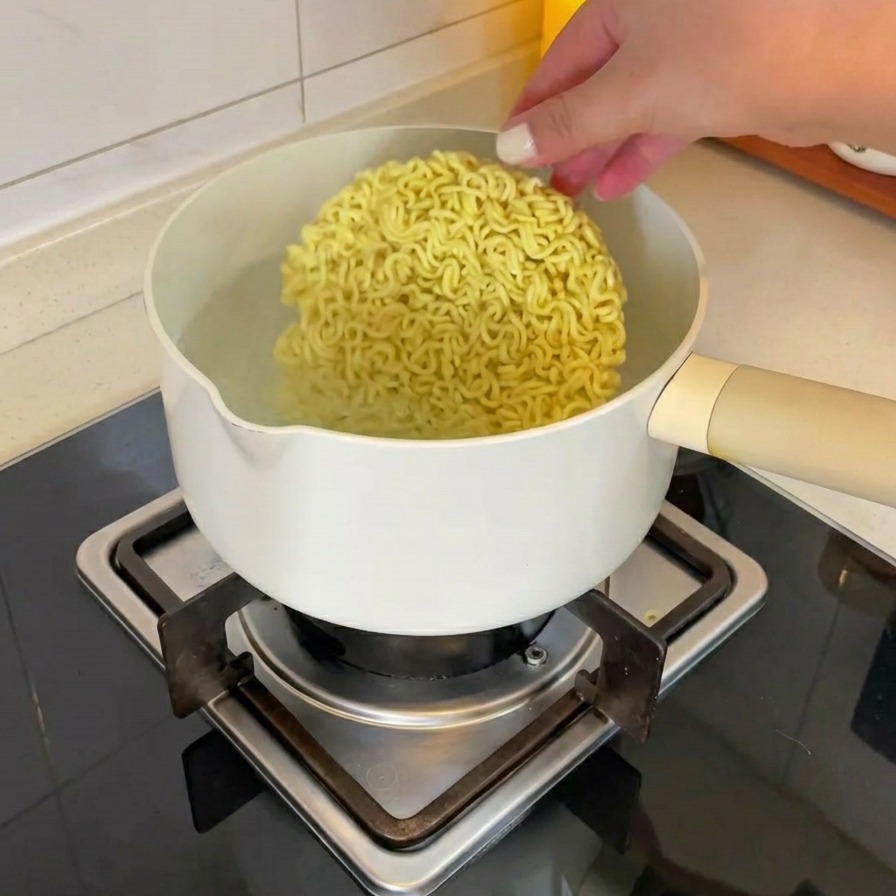 沸騰した鍋にインスタントラーメンの乾麺を入れている様子。