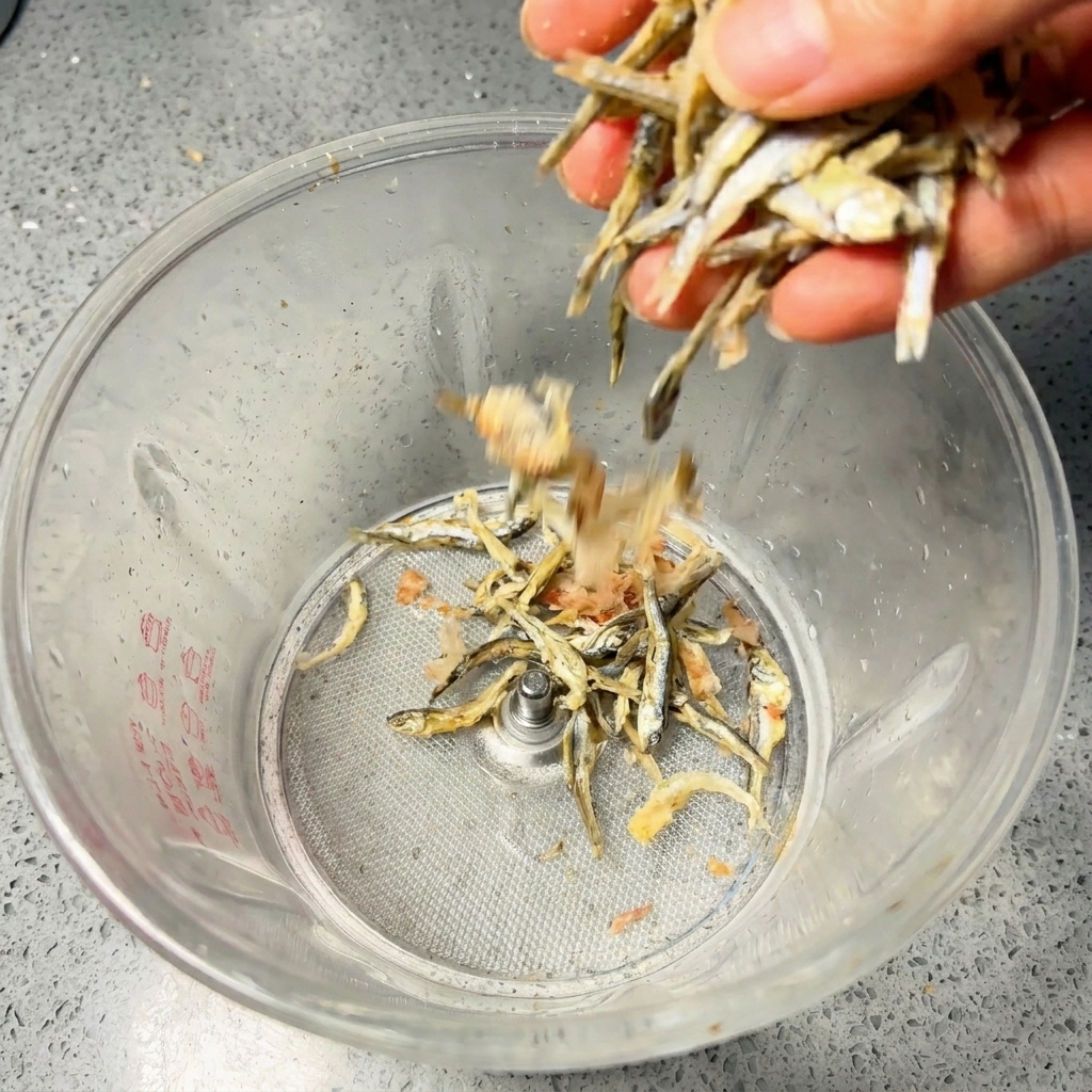 ブレンダーの容器に煮干しと鰹節を入れている様子