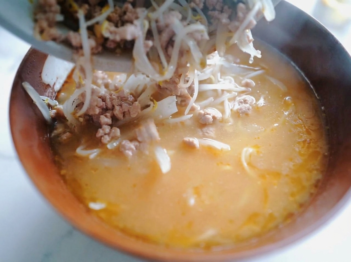 味噌ラーメンの上に、炒めた挽肉ともやし、半熟卵、ねぎを美しく盛り付けた完成形。