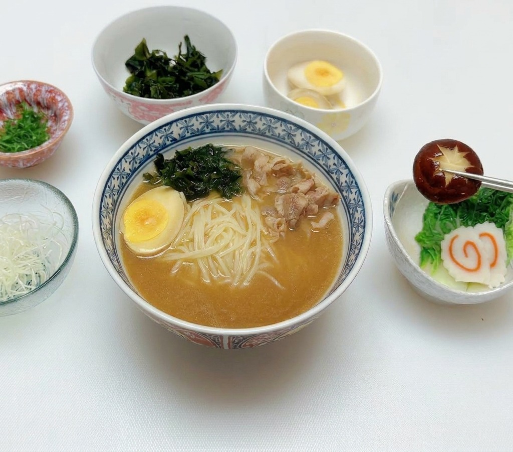 箸を使って、飾切りした椎茸となるとをトッピングしている様子。