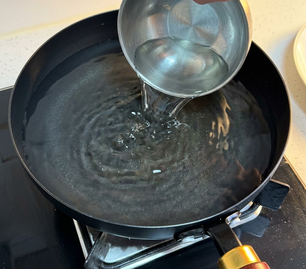 沸騰したお湯に冷水を注いで温度を下げている様子。