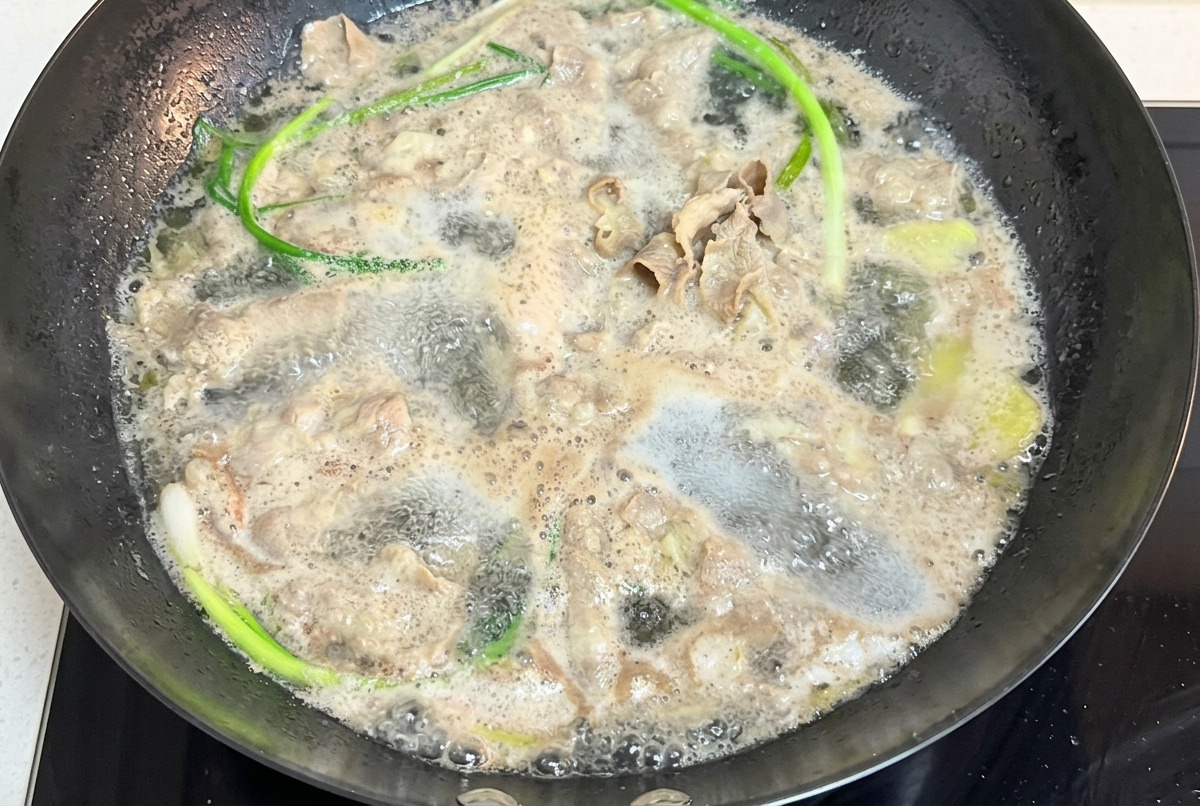 沸騰したお湯の中で牛肉とねぎを一緒に茹でている様子。