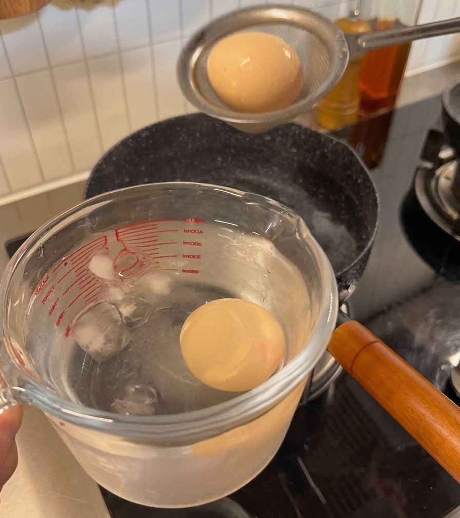 卵を氷水の入った容器に移している様子。