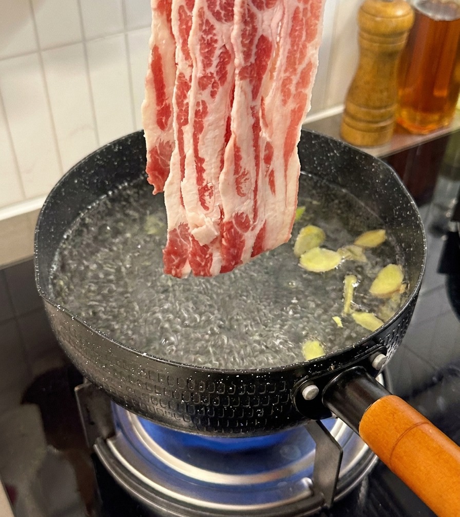 生姜を入れたお湯で牛肉を茹でている様子。