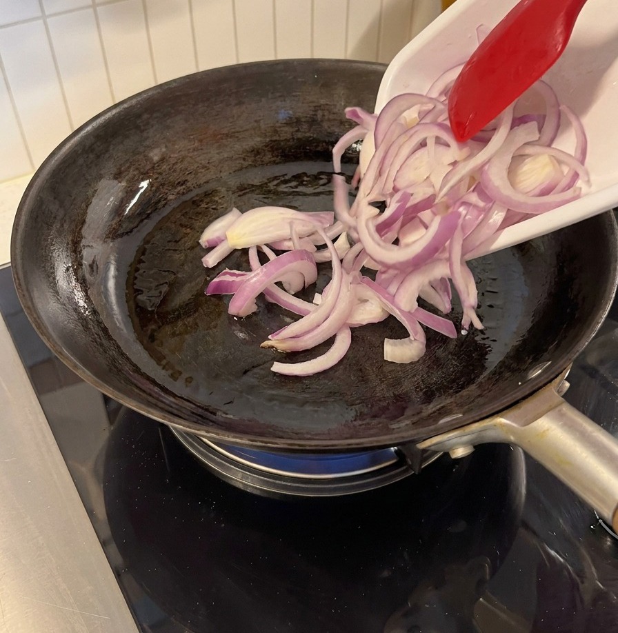 フライパンで赤玉ねぎを炒めている様子。