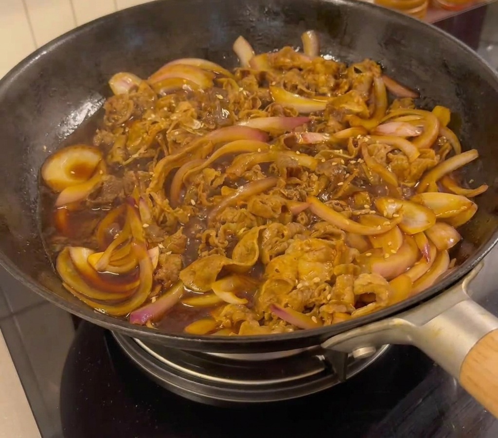 牛肉に青ねぎといりごまをトッピングした様子。