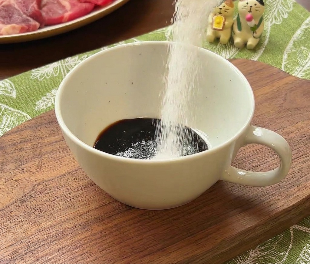 醤油ベースのタレに白砂糖を加える様子。