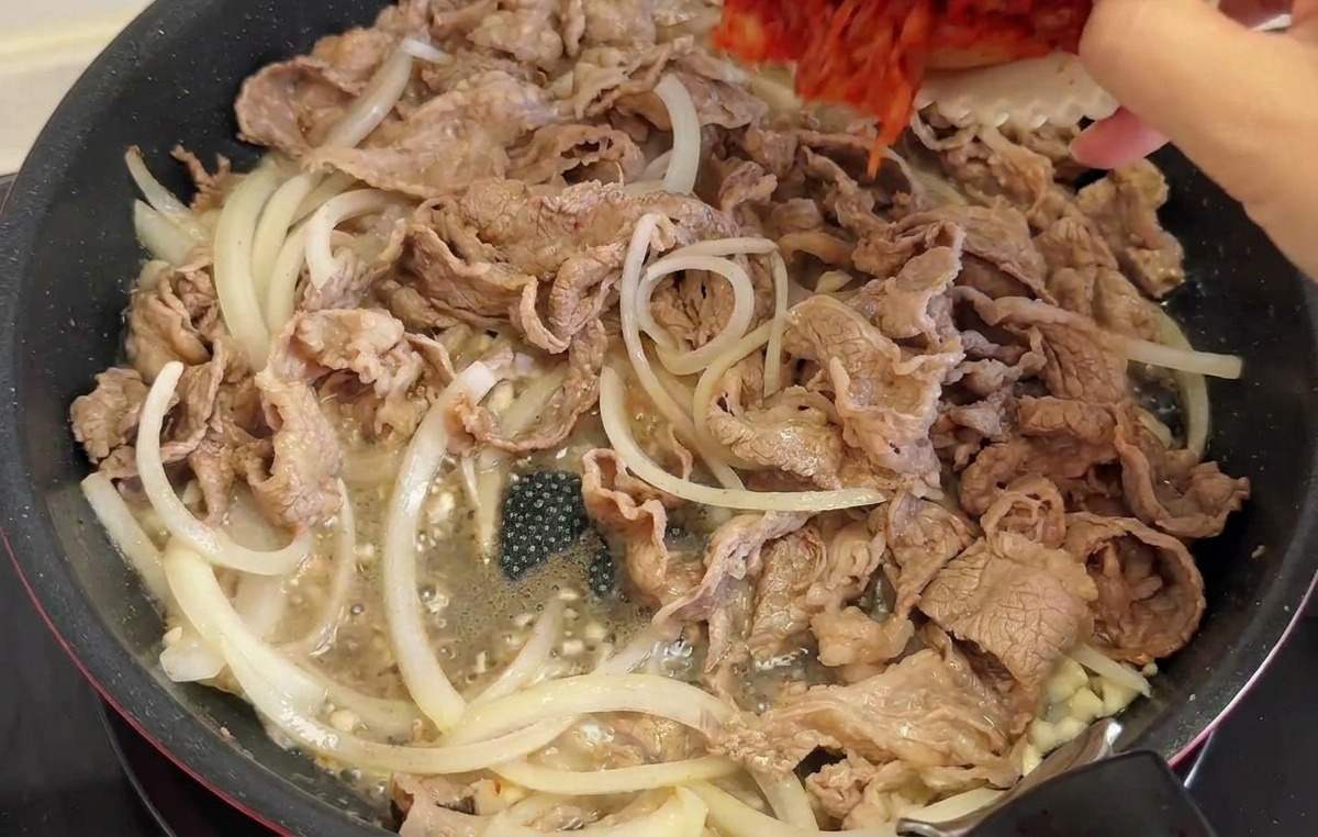 キムチと青唐辛子をフライパンに投入する様子