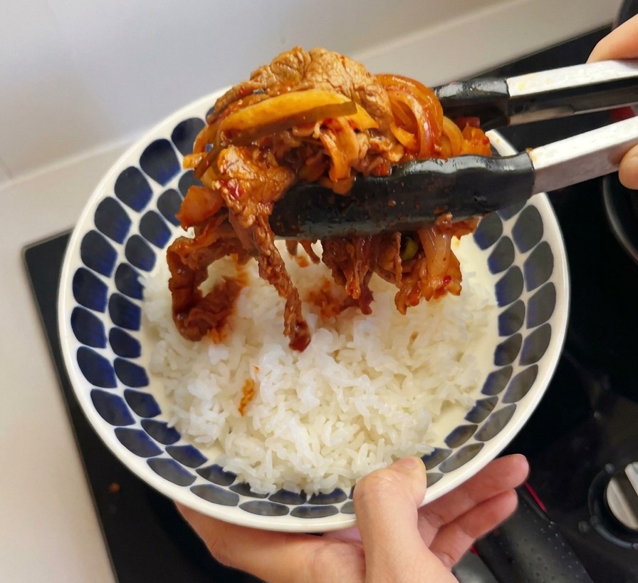 ご飯の上に具材を盛り付ける様子