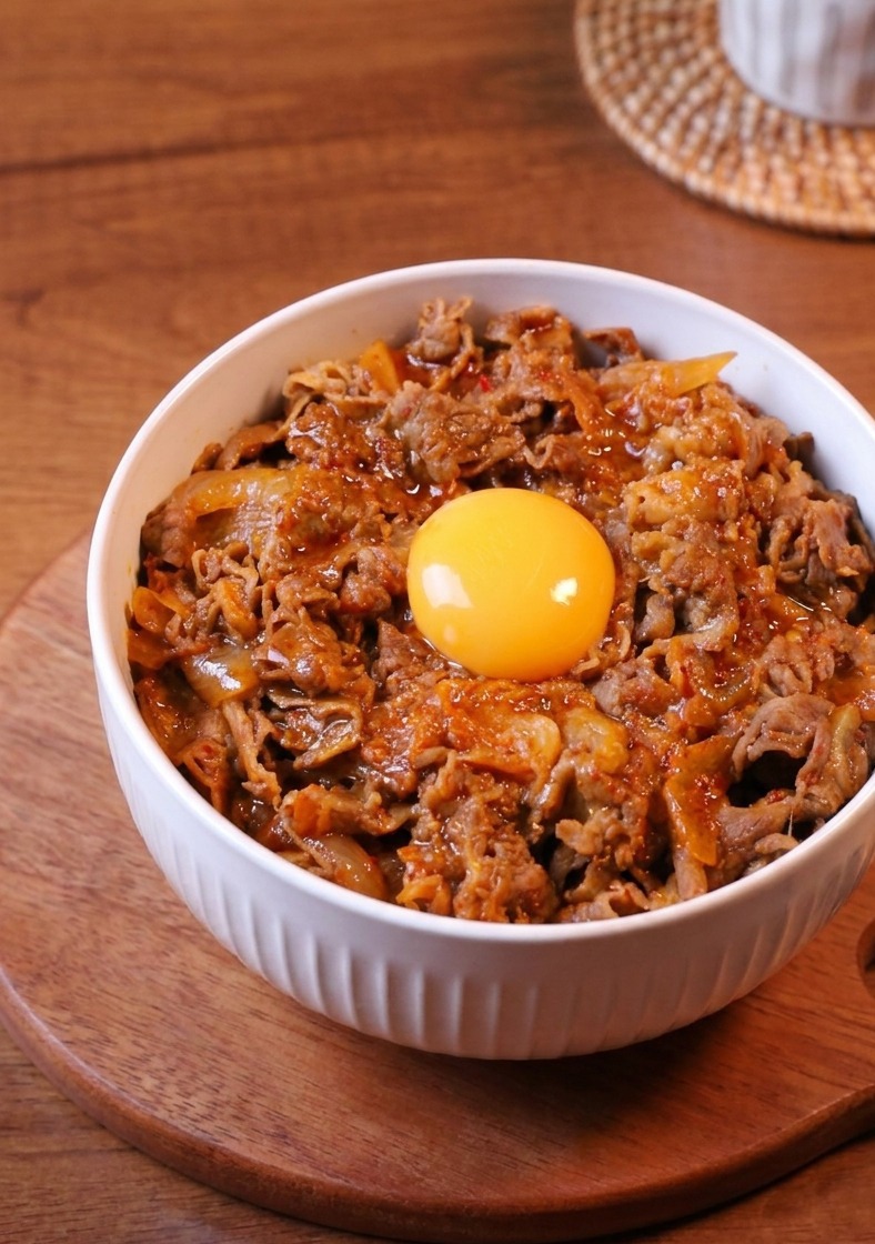 熱したフライパンに薄切りの牛バラ肉を並べている様子。