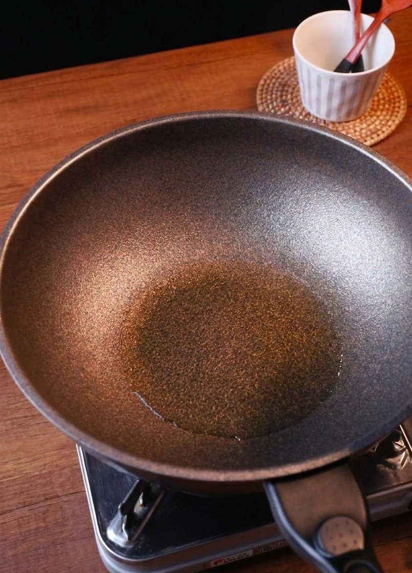 牛肉の旨味が残ったフライパンにスライスした玉ねぎとキムチを入れる様子。
