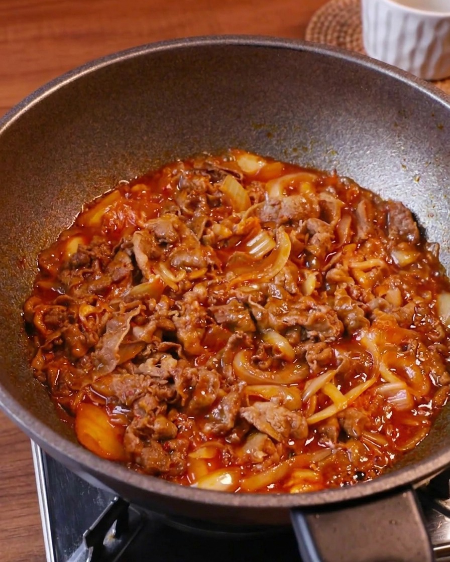 強火でグツグツとタレが煮詰まり、牛肉とキムチに艶が出ている様子。