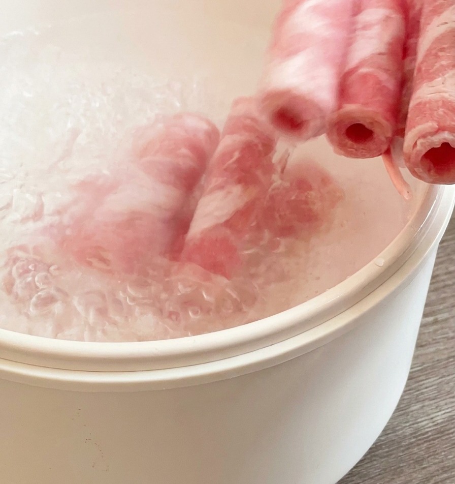 沸騰したお湯に牛薄切り肉を入れ、さっと湯通しする様子