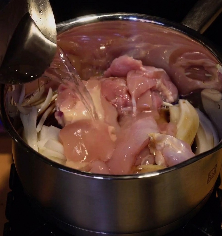 具材が入った鍋に、水を注いでひたひたにしている様子。