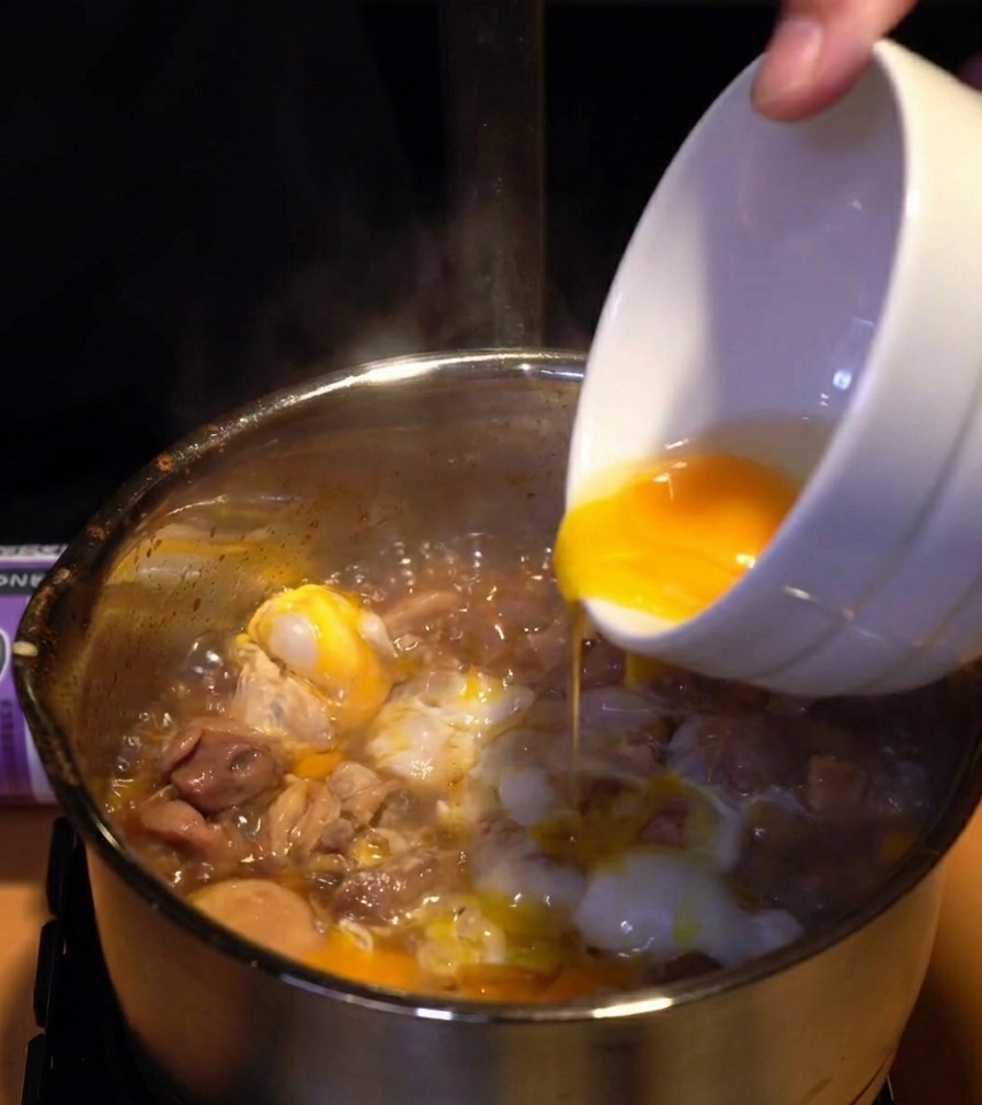 固まりかけた白身の上に、鮮やかな黄身を回し入れている様子。