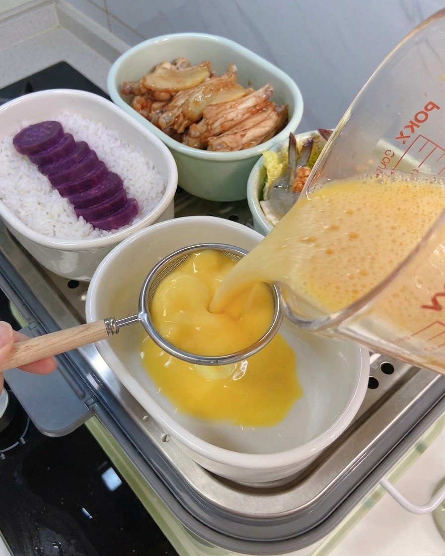 卵液をこし器を通してセラミックボウルに注いでいる様子。