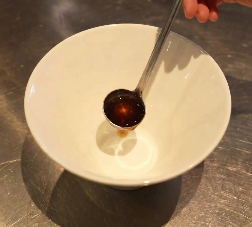 白い丼の底に塩タレを注ぐ