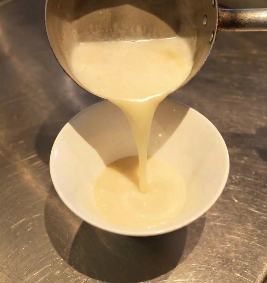 塩タレの入った丼にクリーミーなスープを注ぐ