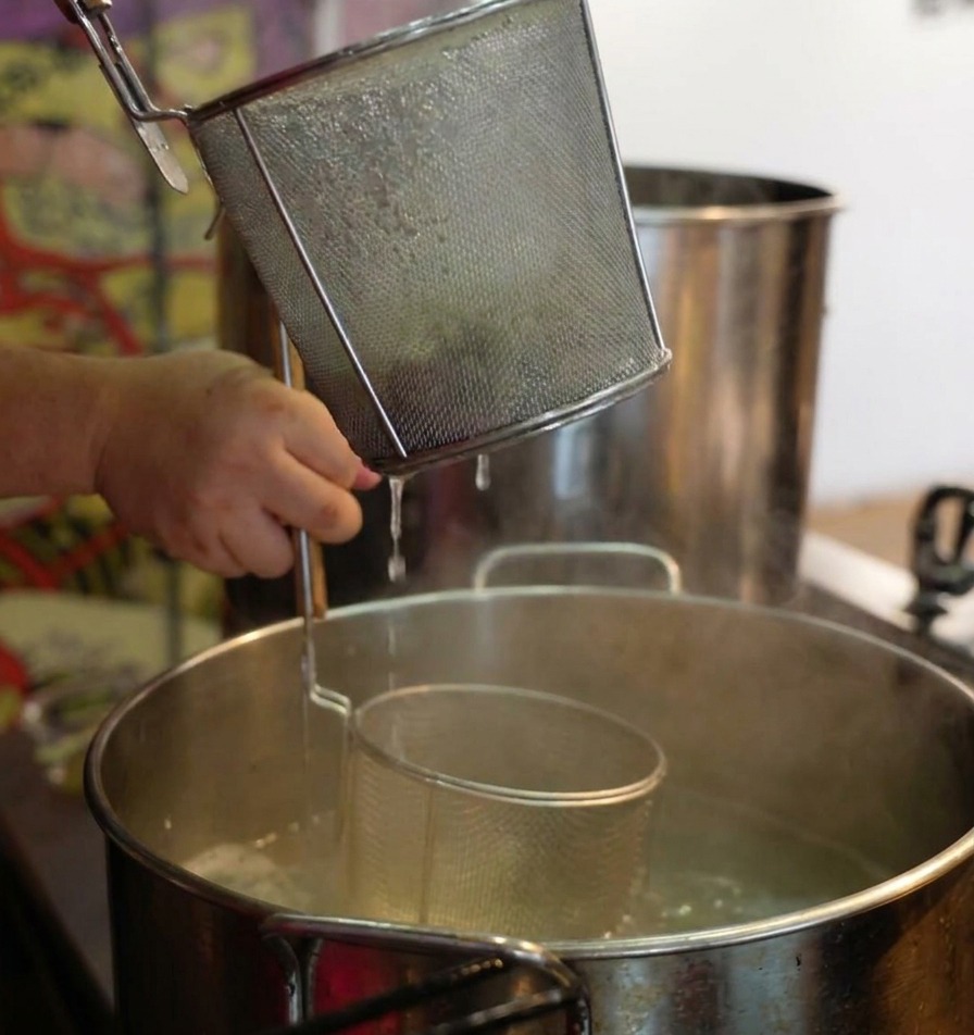 茹で上がった麺を力強く振って湯切りする