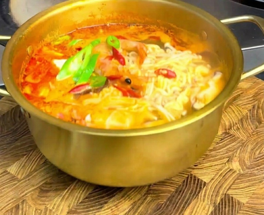木製のボードの上に置かれた、唐辛子がトッピングされた海鮮ラーメン。