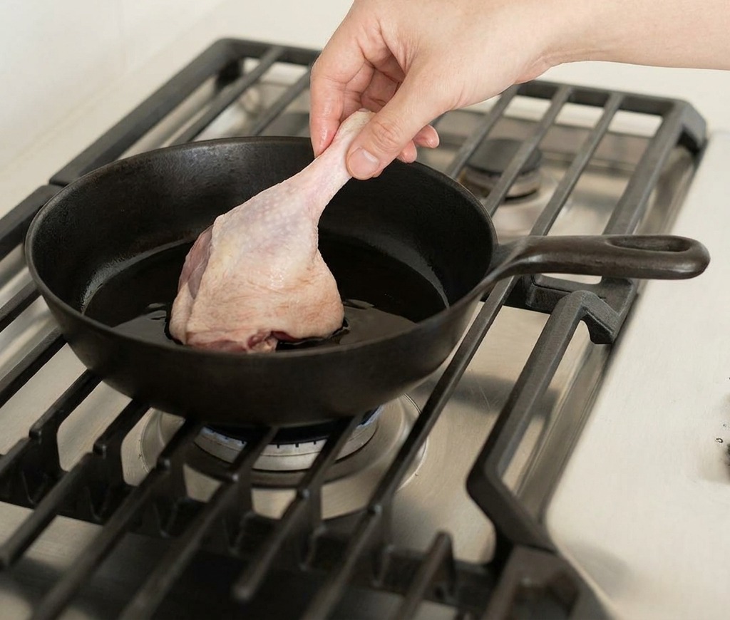 熱したフライパンに生の鴨もも肉を入れる様子。