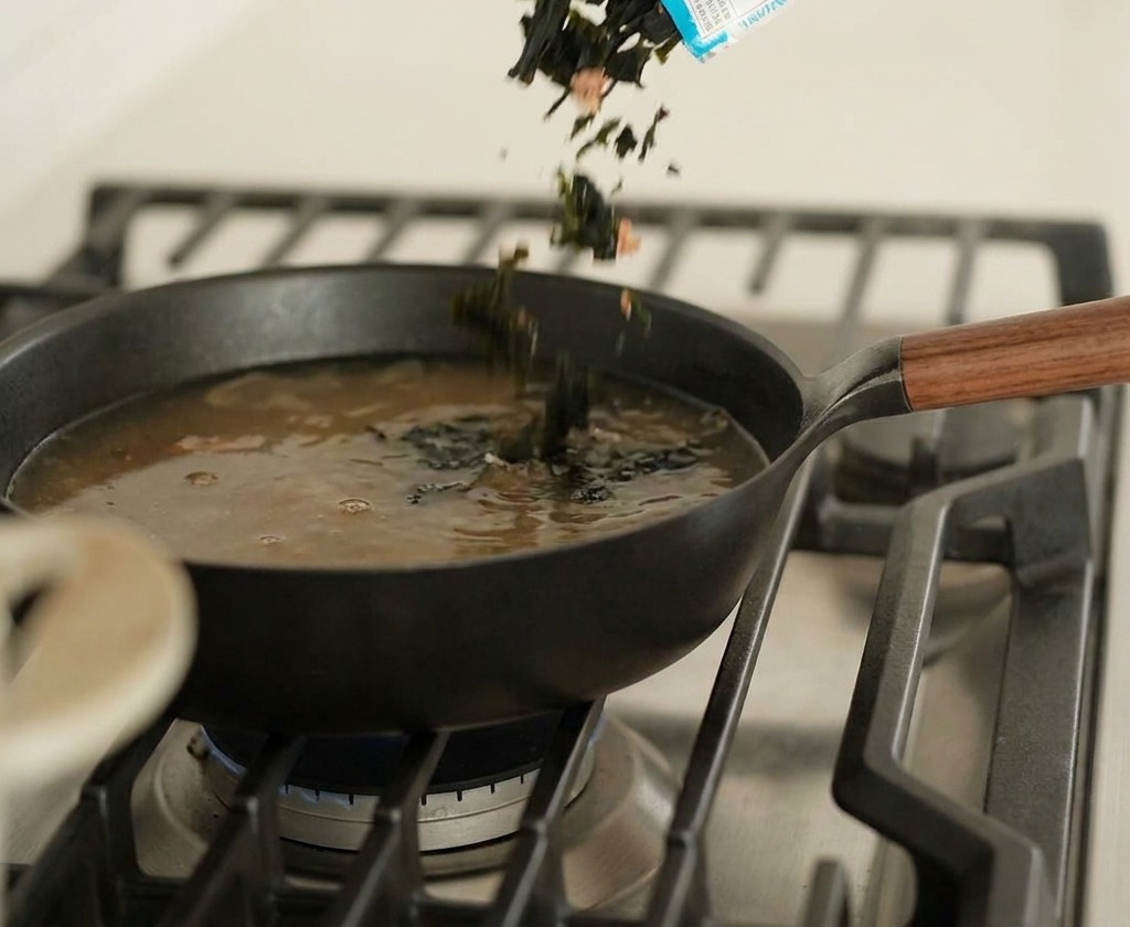 スープに乾燥わかめを直接投入する様子。