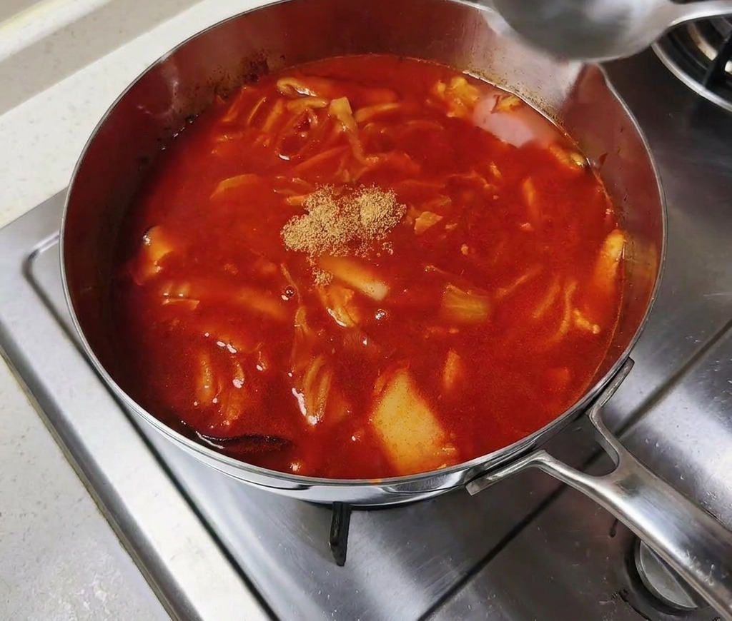 沸騰したスープの真ん中に牛ダシダ粉末を加えている様子。