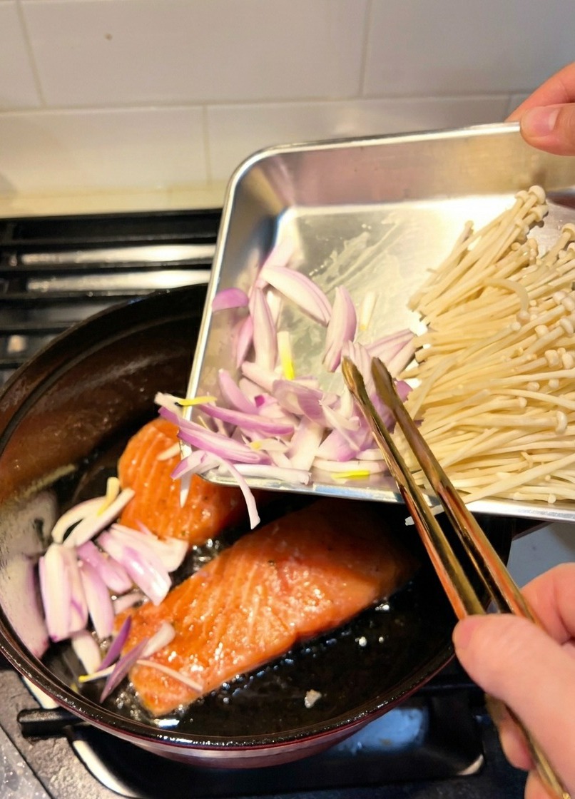 鮭を焼いている横で、スライスしたシャロットを炒めている様子。