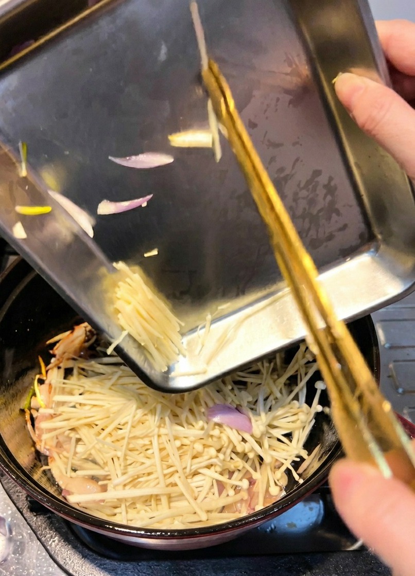 一度鮭を取り出した鍋に、えのきを加えて炒めている様子。