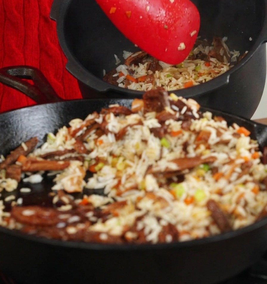 フライパンから炊飯器の内釜へ具材を移している様子。