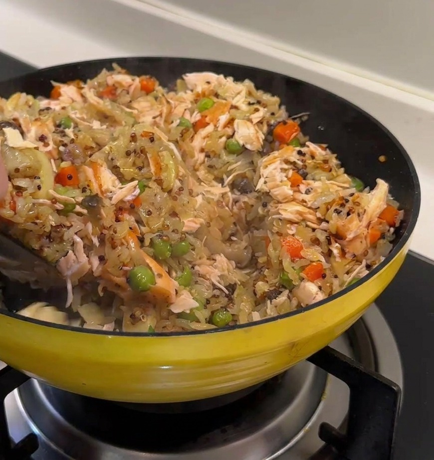 鮭の身と具材、ご飯を全体的に混ぜ合わせている様子。