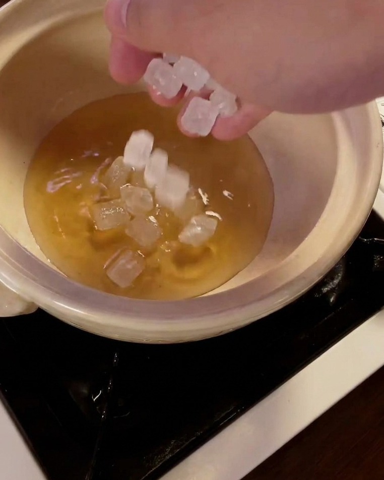 みりんが入った鍋に氷砂糖を投入する様子