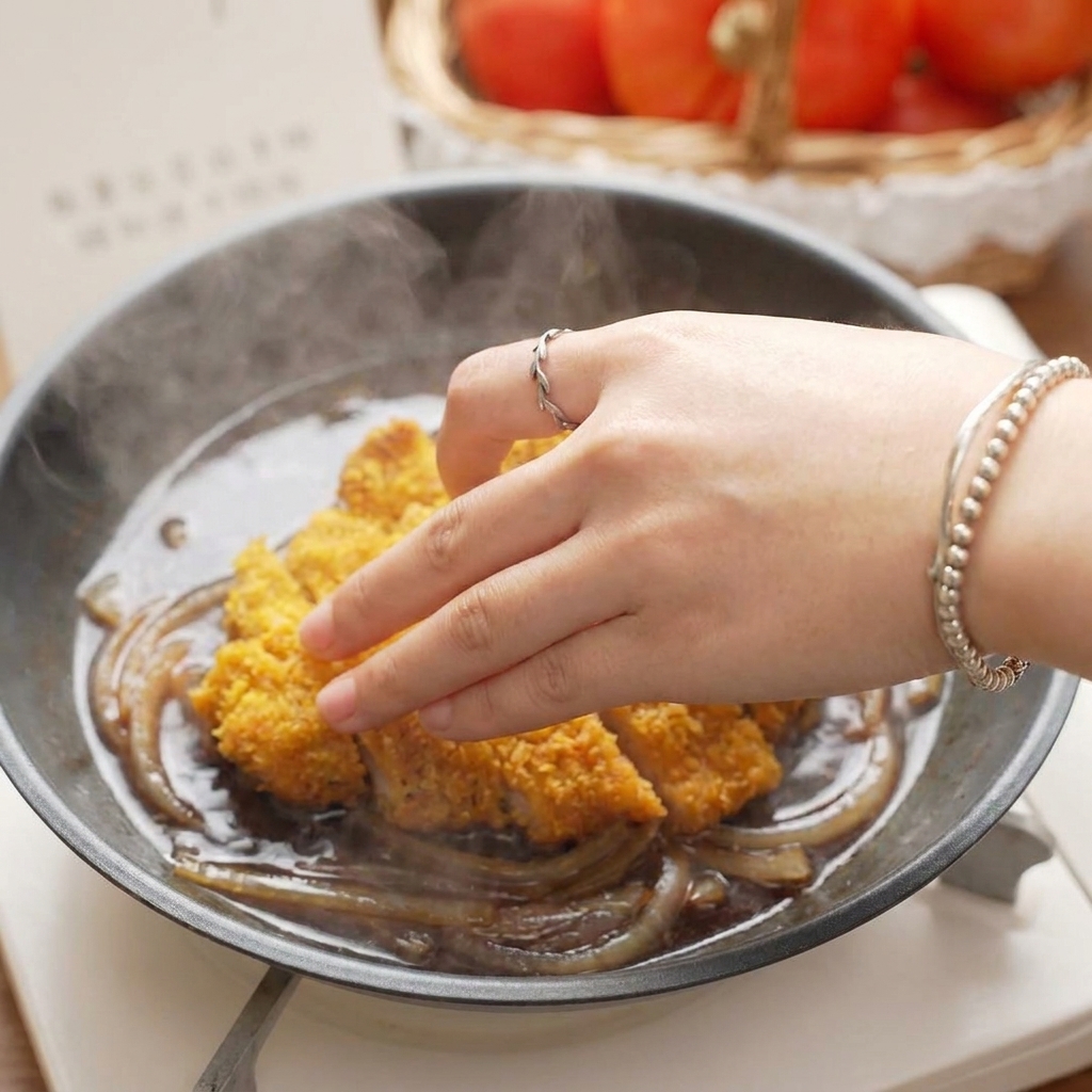 煮えた玉ねぎの上に、カットしたカツを並べている様子。
