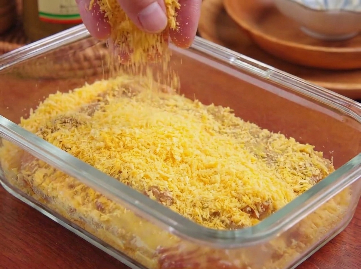パン粉を肉に押し付けてしっかりとした衣を作っている様子