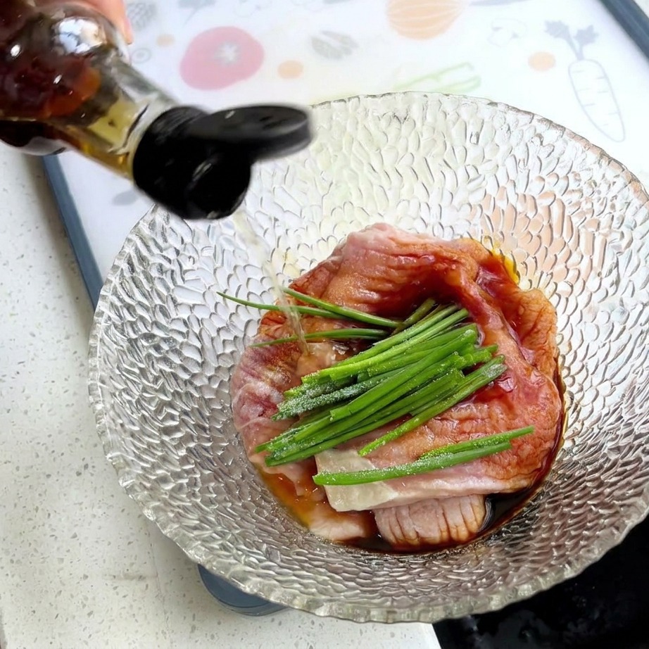 ボウルの中で豚肉に長ねぎや調味料を加えて下味をつけている様子