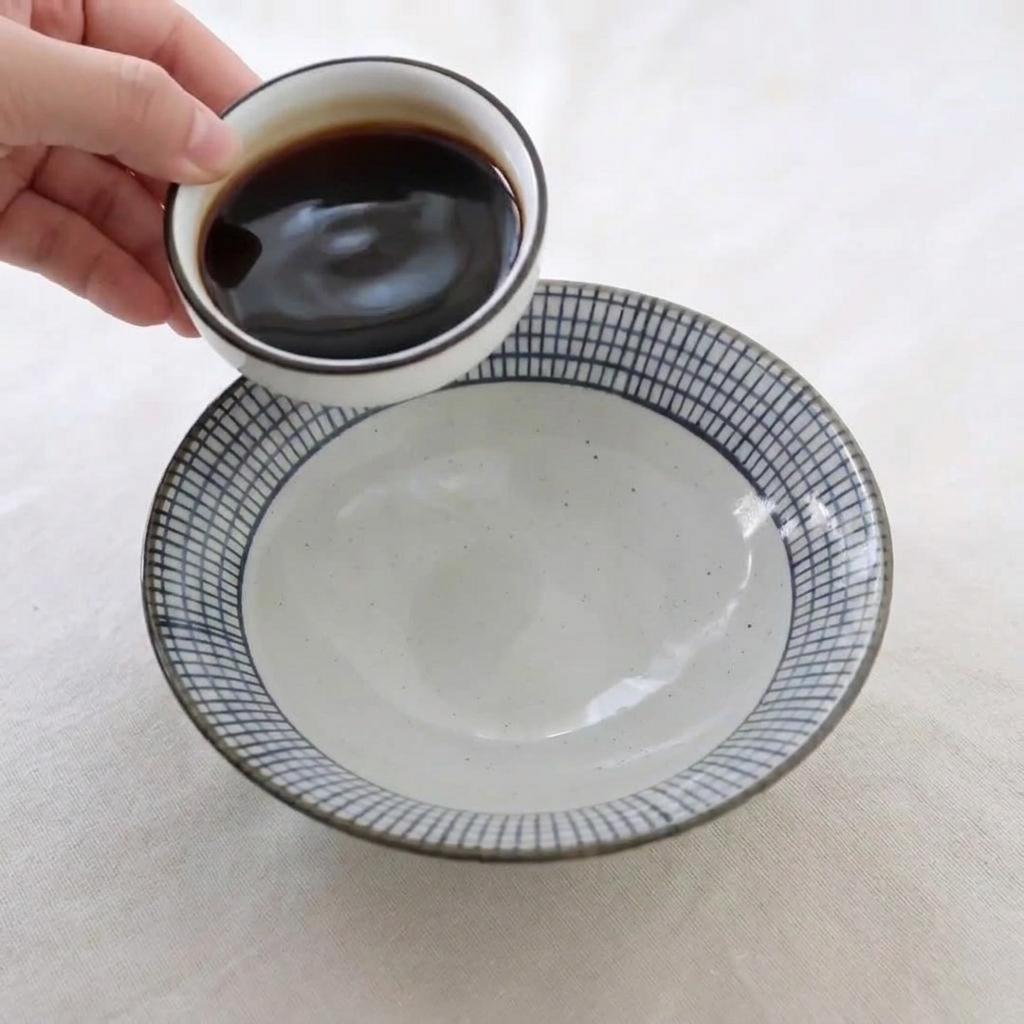 ボウルに醤油やはちみつなどの調味料を注ぎ、混ぜ合わせている様子。