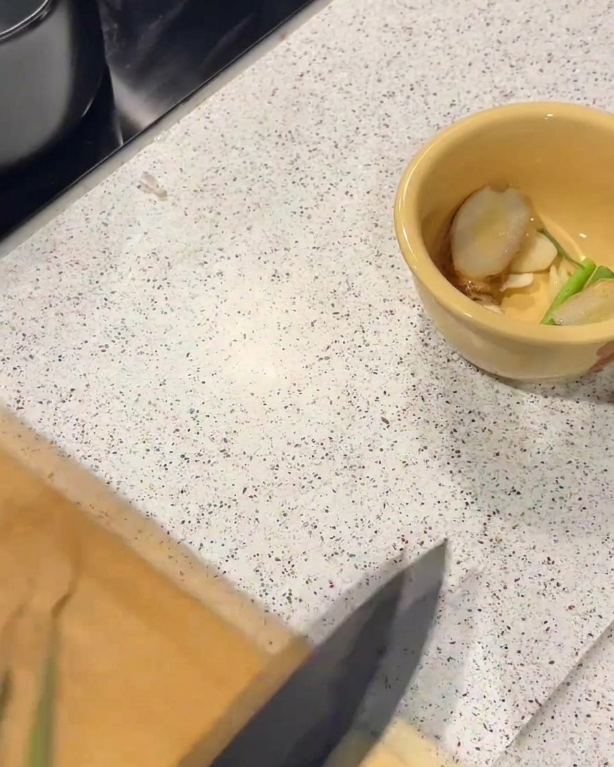 スライスした生姜と刻んだ青ねぎが入った黄色いボウル