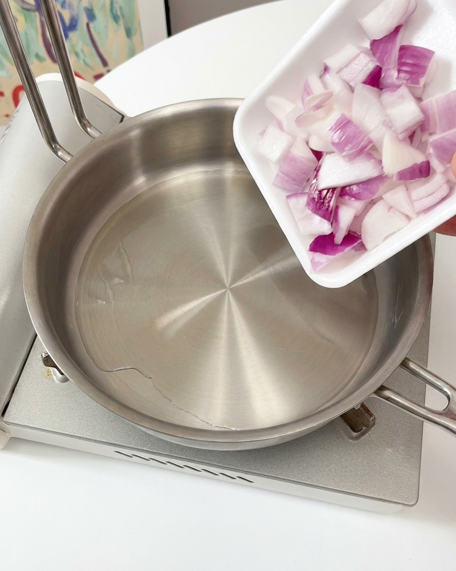 鍋で赤玉ねぎを炒めている様子