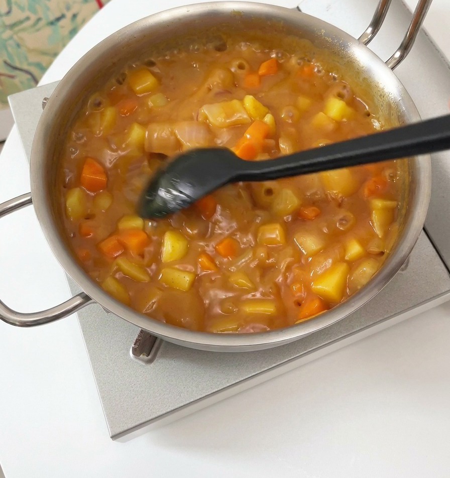 とろみがついたカレーをゆっくり混ぜている様子
